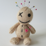 A picture of a cute hand knit voodoo doll, with pins in its head