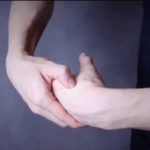 two hands, performing acupressure