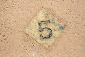 A wooden tile with the number 5 on it.